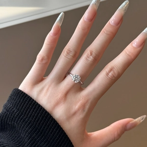 Close-up of S925 sterling silver ring featuring a four-prong set round solitaire moissanite