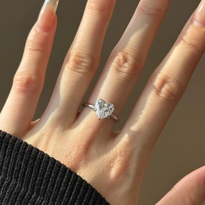 Detail of S925 sterling silver ring with a heart-shaped gemstone on model's hand