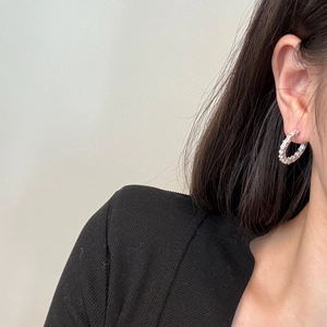 Detail of S925 sterling silver hoop earrings with baguette-cut cubic zirconia on model