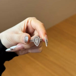Detailed view of S925 sterling silver pear-shaped halo ring set on hand