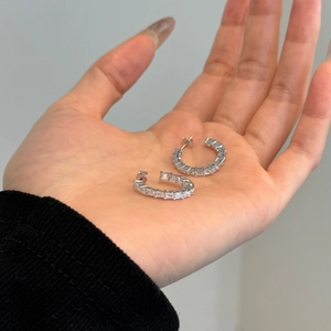 Close-up of S925 silver C-shaped earrings with baguette-cut pavé cubic zirconia