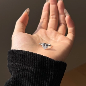 Detailed view of an S925 sterling silver heart-shaped solitaire ring on a hand