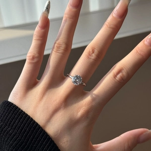 Close-up of sparkling round-cut solitaire diamond ring in classic four-prong silver setting