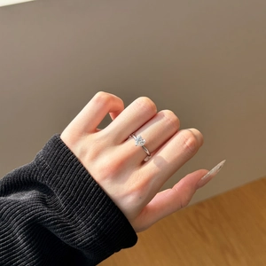 Macro shot of an S925 sterling silver heart-shaped diamond engagement ring on a finger