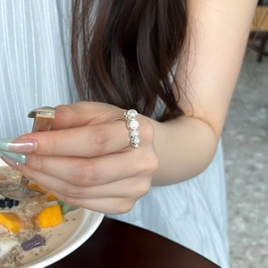 Detail shot of a minimalist S925 silver ring with five white pearls in a daily life scene