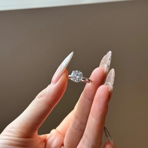 Macro detail of a classic four-prong S925 sterling silver ring with a large round solitaire