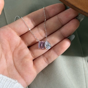 Détail du collier double pendentif avec gemme rose émeraude et pierre blanche en poire