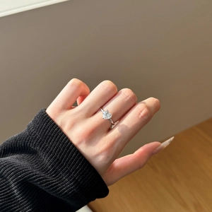 Close-up of a heart-cut cubic zirconia silver ring worn on hand in natural sunlight