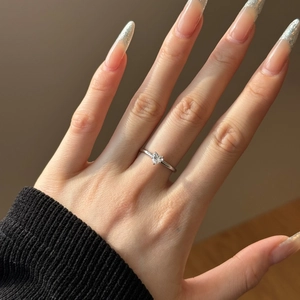 Close-up of S925 silver engagement ring featuring a heart-shaped diamond on a finger
