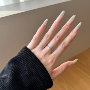 Detailed view of a silver solitaire ring with a round cz stone on a female hand