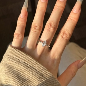Macro view of marquise-cut diamond ring in S925 silver on hand with warm lighting