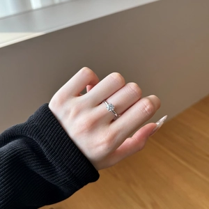Detail of a sparkling S925 silver engagement ring with a six-prong round moissanite on hand