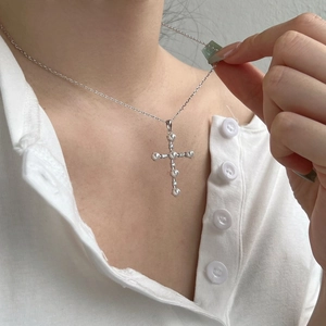 Collana a croce in argento S925 con perle e zirconi indossata da una modella donna