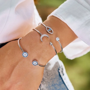 Detail of S925 silver evil eye open bracelets with cubic zirconia on model's wrist