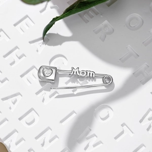 Close-up of S925 sterling silver Mom brooch with heart-shaped zircon on a textured stone