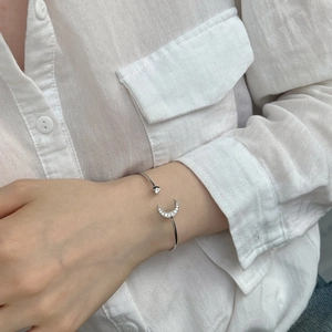 Close-up of S925 sterling silver moon and star open bangle with pavé cubic zirconia
