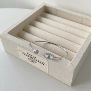 Détail d'un bracelet en argent S925 avec un motif d'œil maléfique et pierre bleue