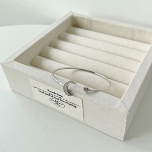 Detailed close-up of a silver crescent moon and heart charm bangle with sparkling zircons