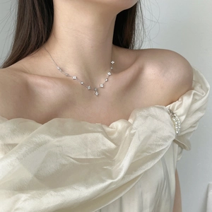 Close-up of S925 silver clover necklace with zircon inlay on a model's collarbone