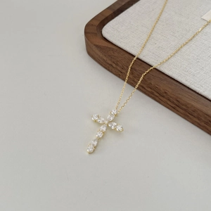 Vue détaillée d'un collier pendentif croix en or avec des zircons en taille poire