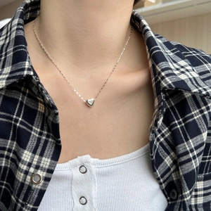 Close-up of a 3D heart pendant in S925 sterling silver worn on a woman's neck