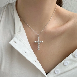 Elegant S925 sterling silver cross necklace with round pearls shown on a female model