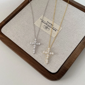 Élégants colliers croix en argent S925 et or avec zircons sur un plateau en bois