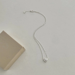 Macro shot of S925 sterling silver heart pendant with adjustable box chain on grey base