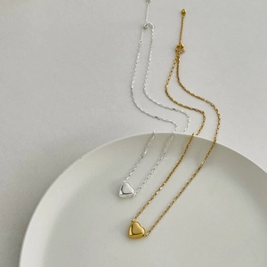Detailed close-up of polished S925 silver heart pendants in gold and silver finishes
