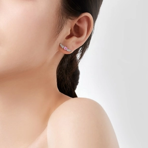 S925 silver wing stud earrings with pink heart zircon on model's ear in close-up