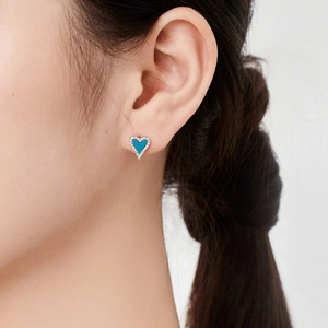 Gros plan d'une boucle d'oreille cœur en argent avec turquoise bleue et pavé de zircons