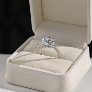 Macro shot of oval cut diamond ring with pavé band in a luxury velvet jewelry box