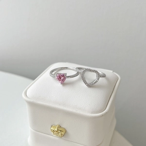 Detail of S925 silver heart rings set with pink zircon on white leather jewelry box