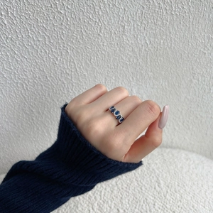Macro view of wave design S925 silver ring with blue pear-cut zircon and pavé diamonds