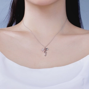Close-up of S925 silver necklace featuring starfish, shell, and seahorse charms on a model