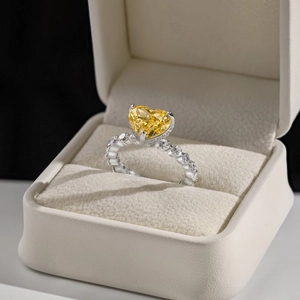 Sparkling S925 sterling silver heart-shaped yellow diamond ring in a beige jewelry box