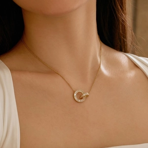 Close-up of golden interlocking rings pendant with baguette-cut cubic zirconia on a necklace