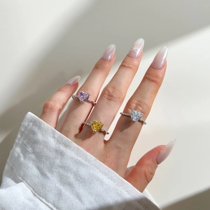 Trois bagues en zircon en forme de cœur rose, jaune et blanc portées par un mannequin