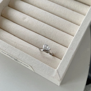 Detailed macro of a teardrop-shaped zircon silver ring with a bypass band in a jewelry box
