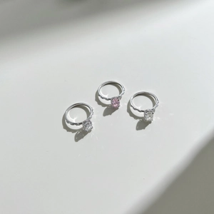 Dettaglio di tre anelli in argento S925 con zirconi ovali rosa e trasparenti