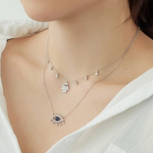 Gros plan du collier double épaisseur en argent S925 avec main de Hamsa et œil bleu