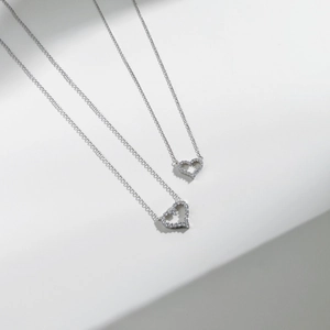 Deux pendentifs coeur évidé en argent 925 avec pavé de zircons blancs sur chaîne en O