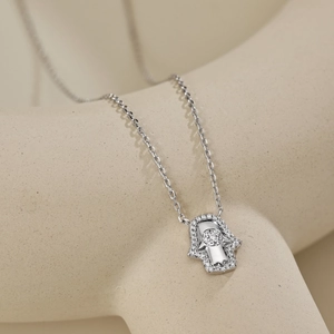 Macro d'un pendentif Main de Fatma en argent avec zircons sur une chaîne fine en O