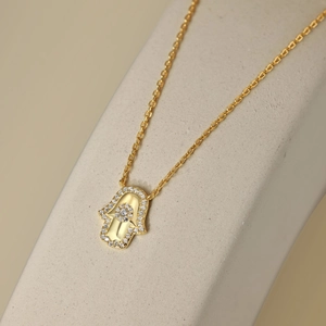 Macro de la main de Fatma en argent S925 doré avec zircons sur un support en pierre