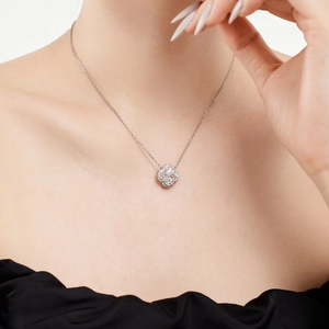 Close-up of a silver S925 four-leaf clover pendant necklace with zircon on a model's neck