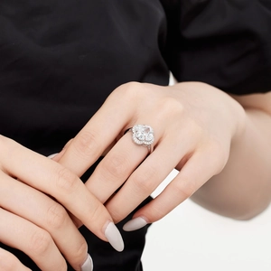 Macro shot of silver S925 ring with princess cut zircon and floral halo on hand