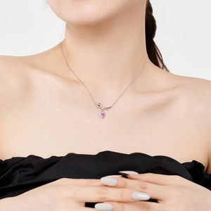 Collier en argent S925 avec pendentif cœur rose et nœud élégant porté par un modèle