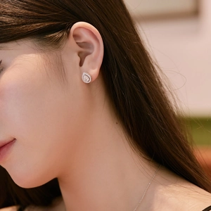 Close-up of S925 silver pear cut drop earrings with zircon halo on female model