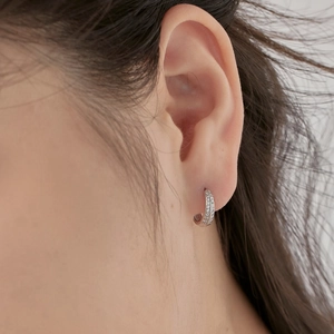 Macro detail of S925 silver hoop earrings with double row sparkling zircon stones