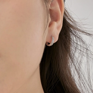 Close-up of curved S925 silver hoop earrings with micro-pave cubic zirconia on ear